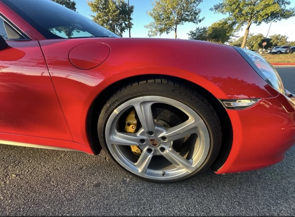 Detailed Porsche wheel and yellow brake caliper